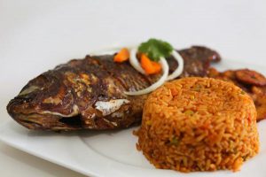 jollof rice served with fried tilapia